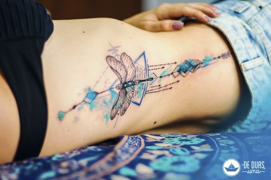tatuagem feminina na costela libélula aquarela