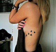 tatuagem feminina na costela pássaros