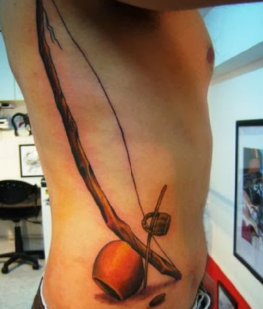 tatuagem masculina na costela berimbau