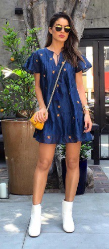 Camila Coelho com vestido azul e bolsa mostarda.