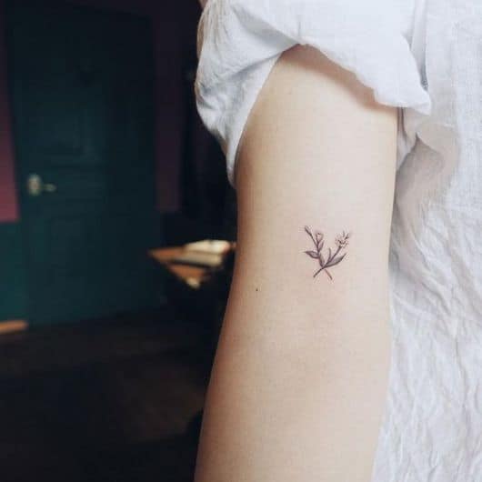 Tatuagem pequena de ramo de flores no braço