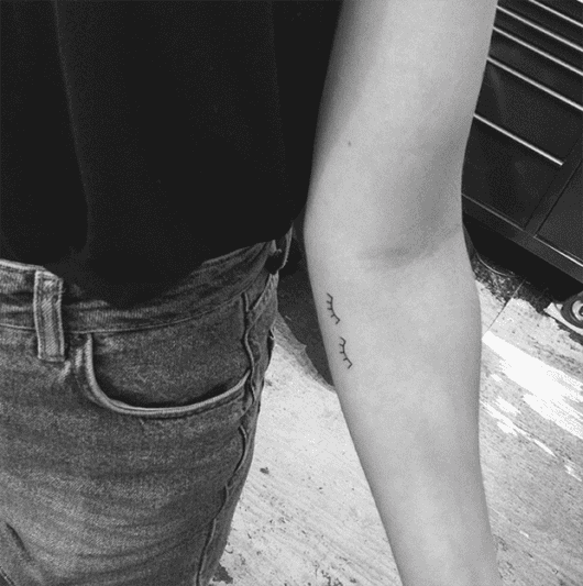 Tatuagem de cílios no braço