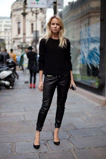 Calça preta de couro, blusa de tricot preta e sapatilha.