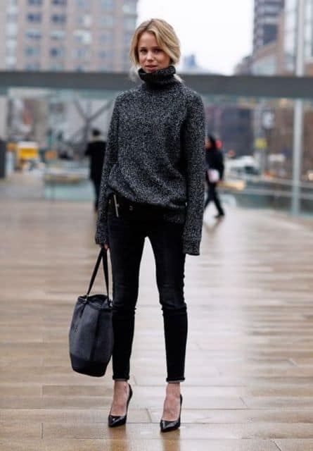 Modelo usa calça preta, blsão de inverno cinza escuro e sapato de salto.