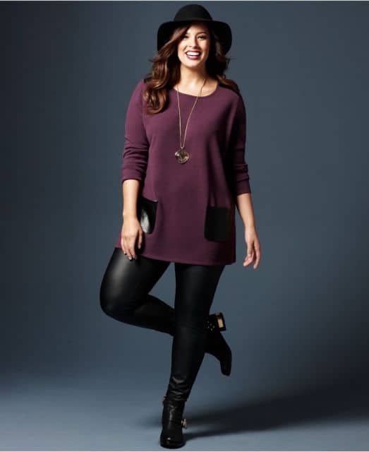Modelo usa blusa mais compridinha vermelho vinho com detalhes de bolso, calça em couro e botinha preta.