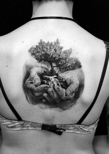 tatuagem de árvore da vida sendo segurado por duas mãos
