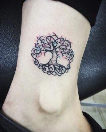 tatuagem de árvore da vida com pinceladas de cor nas folhas