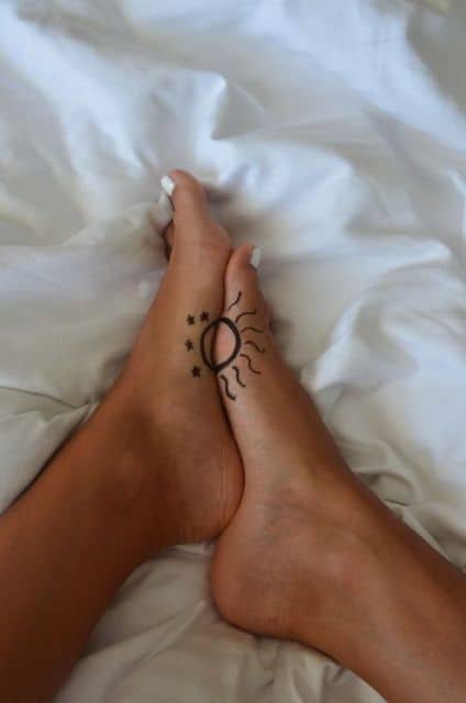 Tatuagem no pé, meia lua e meio sol que se completam.