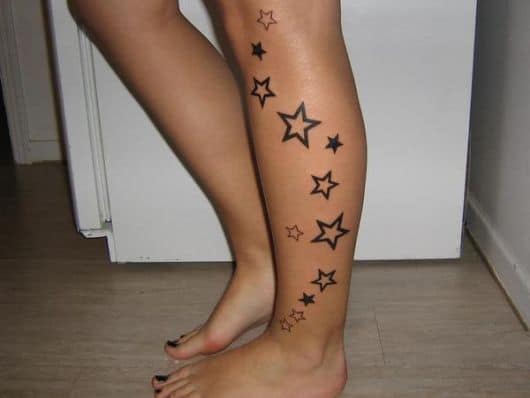 tatuagem de estrela na perna em diferentes tamanhos e algumas preenchidas e outras não
