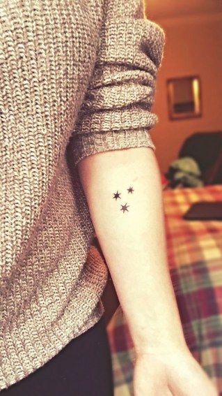 três tatuagens de estrelas no braço