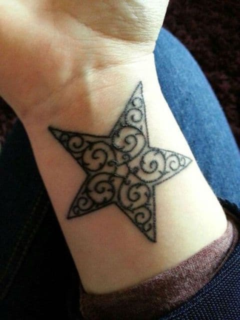 tatuagem de estrela com estampa de desenhos indianos