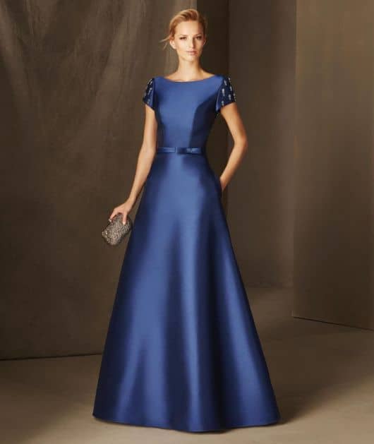 Modelo usa vestido azul marinho longo, para eventos de manguinhas curtas.