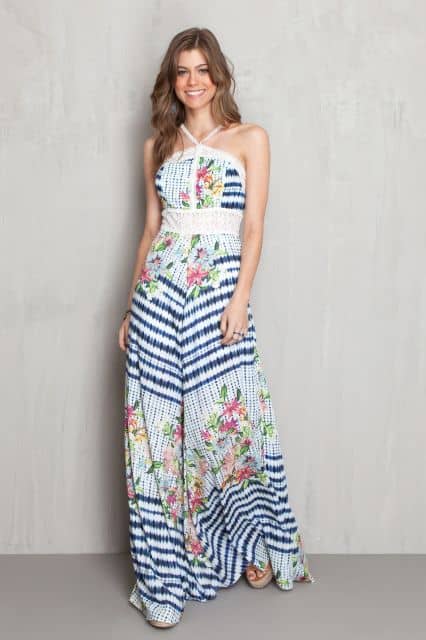 Modelo usa look com vestido branco com estampa azul de listras e flores.