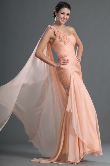 Modelo usa vestido com detalhe de rosas na alça, modelo sereia cor salmão claro.
