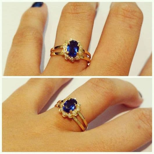 modelo de anel em ouro amarelo com pedra azul escuro.