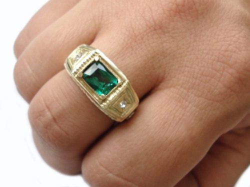 modelo de anel amarelo em ouro, com pedra verde.