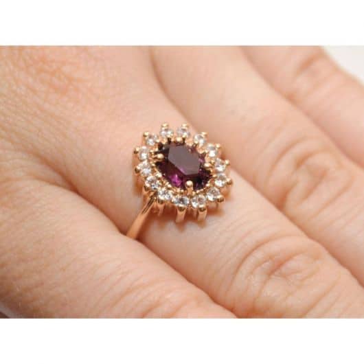 anel em forma de flor com pedra roxinha escuro.