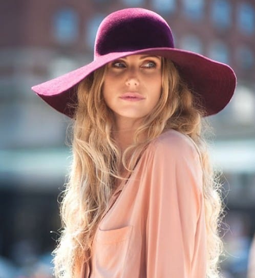 modelo usa blusa rosê com chapeu floppy roxo.