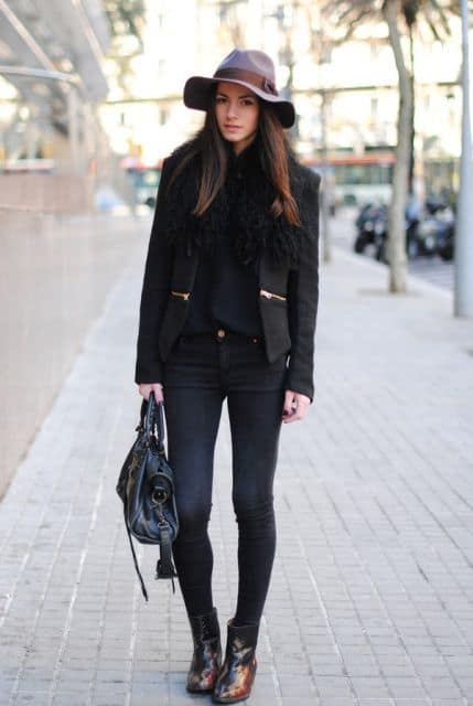 modelo usa calça jeans, blazer, bolsa e chapéu todas peças na cor preta.