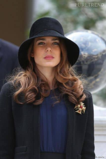 modelo usa chapeu preto, com blusa azul e blazer preto.