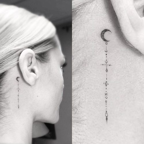 Tatuagem de lua, atras da orelha com traços abaixo.