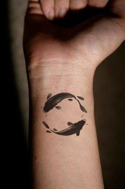 tatuagem de dois peixes em formato redondo