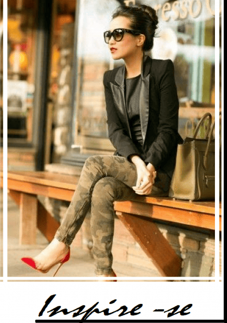 modelo sentada usa calça camuflada. blazer preto e sapato scarpin vermelho.