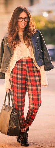 modelo usa cropped de la manga longa,, jaquetinha, calça xadrez vermelha, bolsa e botinha.