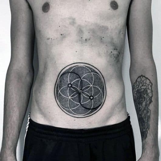Tatuagem geométrica de círculo na barriga de um homem