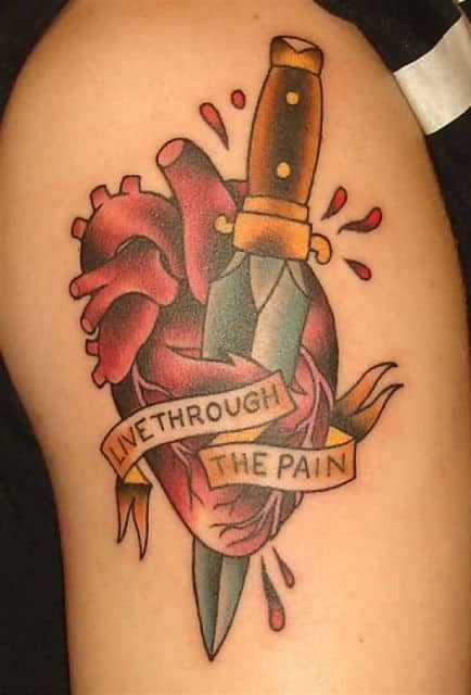Tatuagem de um coração sendo atravessado por um punhal com os dizeres "Live through the pain"