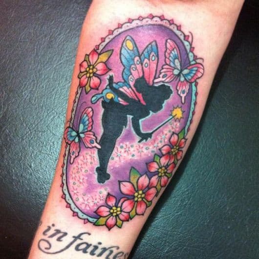 Tatuagem da silhueta da sininho em um espelho, acompanhada por borboletas e flores