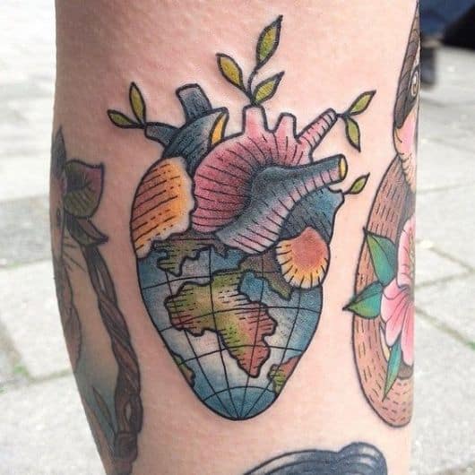 Tatuagem onde o mapa mundi se encontra misturado ao coração de uma pessoa