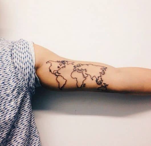 Tatuagem minimalista do mapa mundi na parte interna do braço de uma pessoa