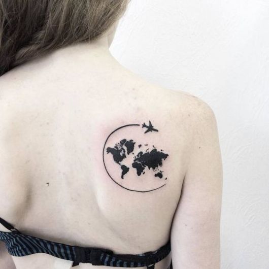 Tatuagem minimalista do mapa mundi com um avião em volta nas costas de uma mulher 