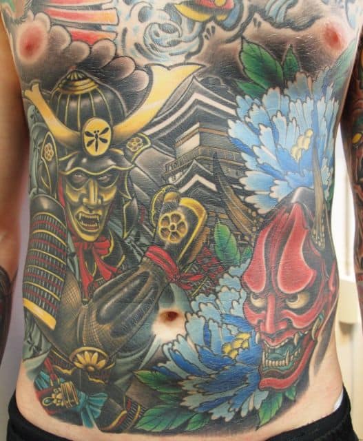 Tatuagem com paisagem oriental e um samurai em destaque na barriga de um homem