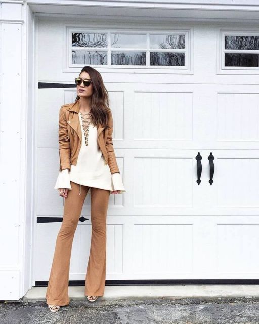 Camila Coelho usa calça suede, blusa branca larguinha e jaqueta de couroi tons terrosos.