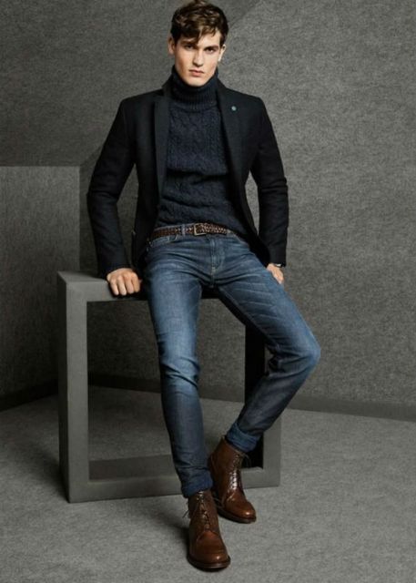 Modelo usa blusa preta, calça jeans, blazer e sapato marrom de couro.