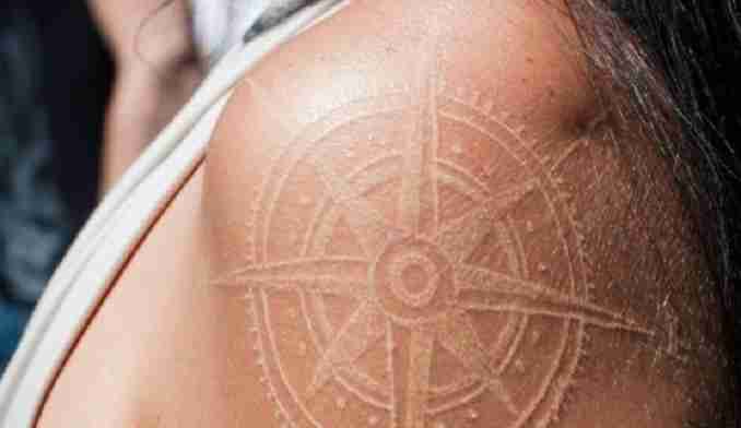 Tatuagem branca de uma bússola antiga 