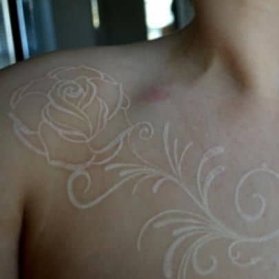 Tatuagem branca de uma rosa no ombro