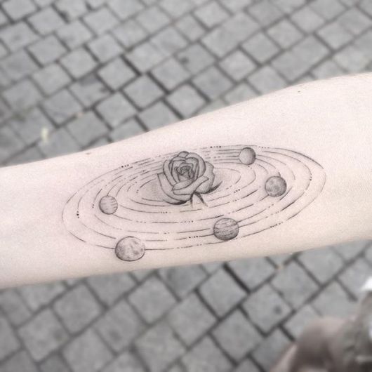 Tatuagem de um sistema planetário com uma rosa no centro