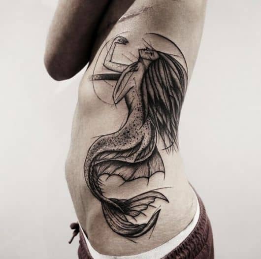 Tatuagem na costela de uma sereia que lembra seres assustadores da mitologia grega devido a sua cauda com espinhos e cabelo espetado.