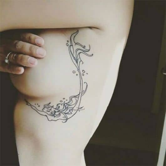 Tatuagem de uma sereia simples que circunda o peito de uma mulher.