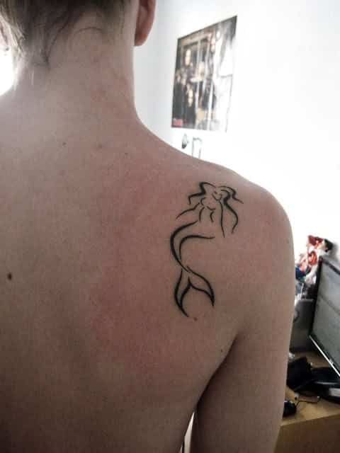 Tatuagem pequena e delicada feita somente com traços que revelam a figura de uma sereia