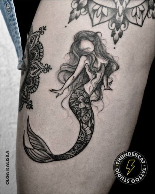 Tatuagem de uma sereia delicada que tem o rosto em branco próxima a outras duas tattoos de mandala