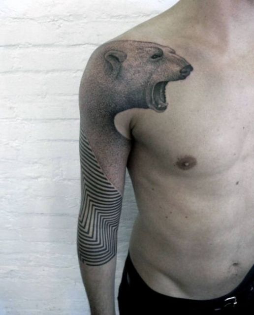 Tatuagem no braço de um urso polar rugindo que termina em diversas linhas geométricas 