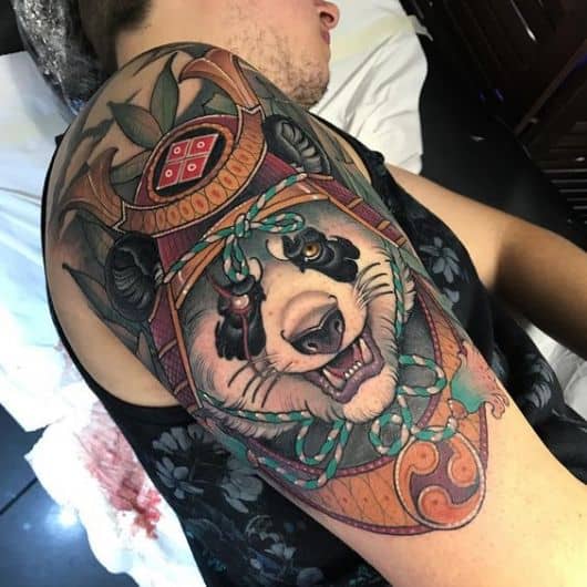 Tatuagem na parte superior do braço de um urso panda vestido de samurai