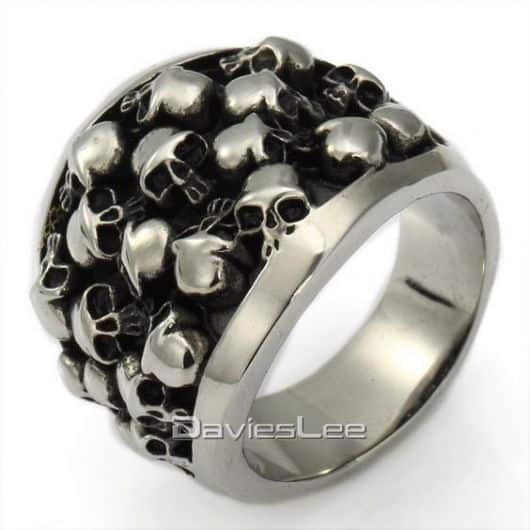 Modelo de anel na cor prata com varias caveirinhas pequenas.