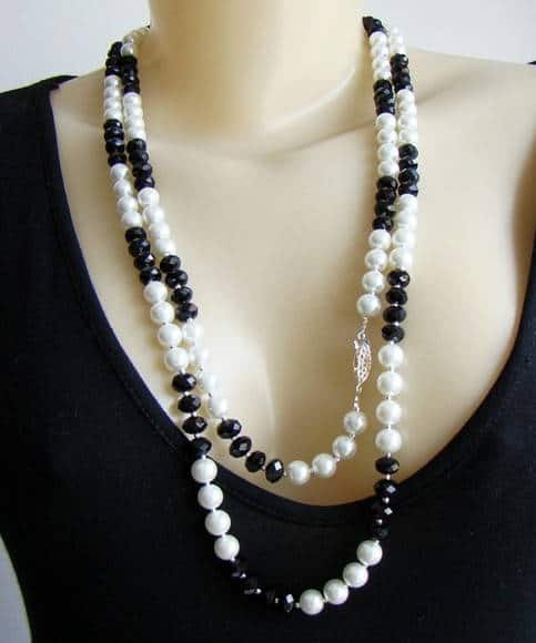 Manequin usa colar de pérolas nas cores branco e preto.