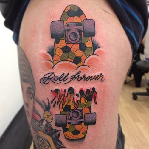 Tatuagem de skate na costela com os dizeres "Roll Forever"