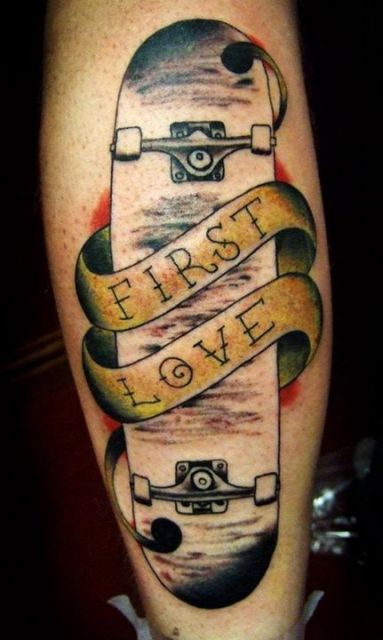 Tatuagem simples de um skate com uma faixa em seu centro escrita "First Love"